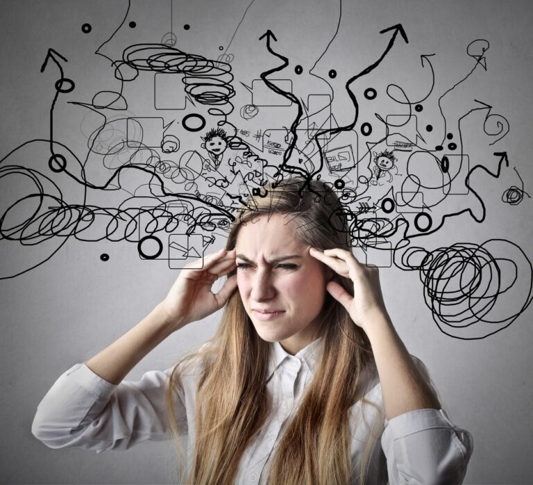 Young woman holds her temples, portraying stress and overwhelm, with chaotic doodles and arrows emanating from her head, symbolizing mental clutter.